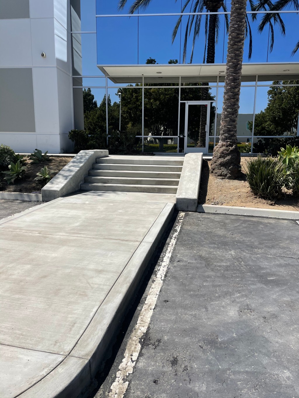 New concrete walkway and steps at an office building entrance