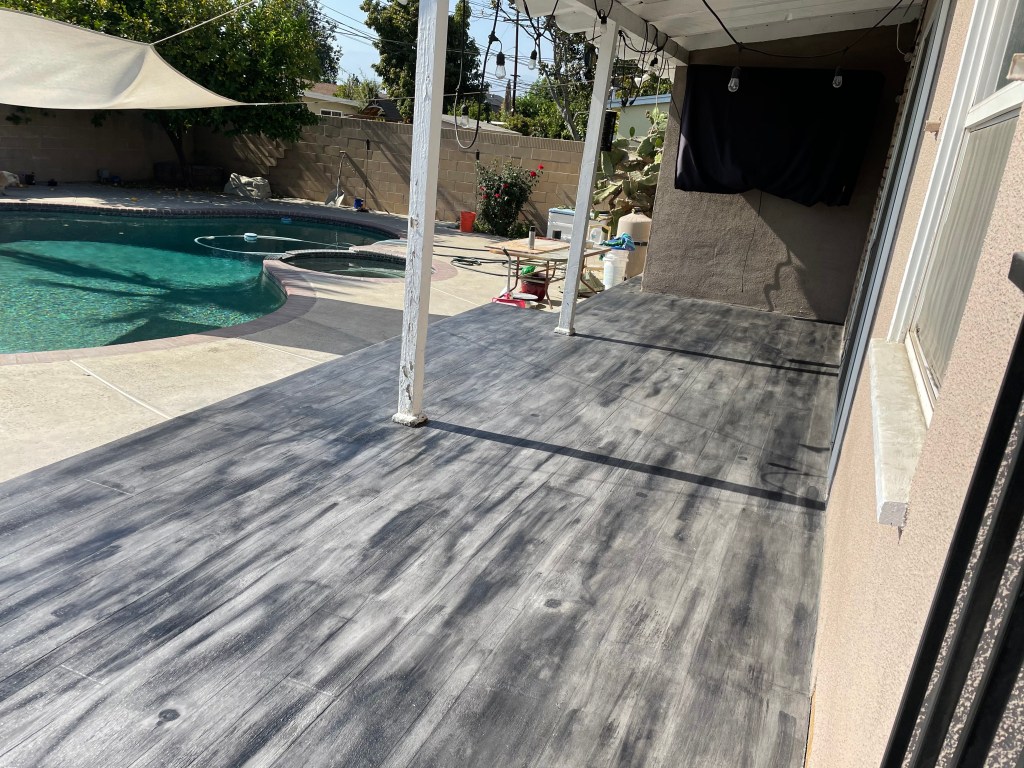 Stained concrete patio next to a backyard pool