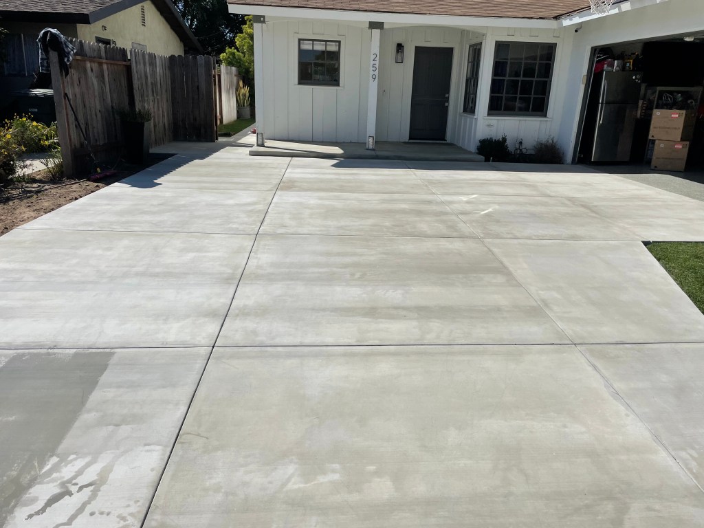 Finished broom-finish concrete slab in a backyard