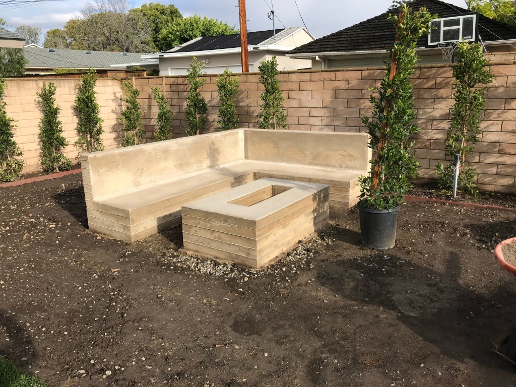 Smooth block seating wall around a backyard fire pit
